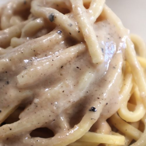 Presentazione del condimento cacio e pepe su elegante piatto 